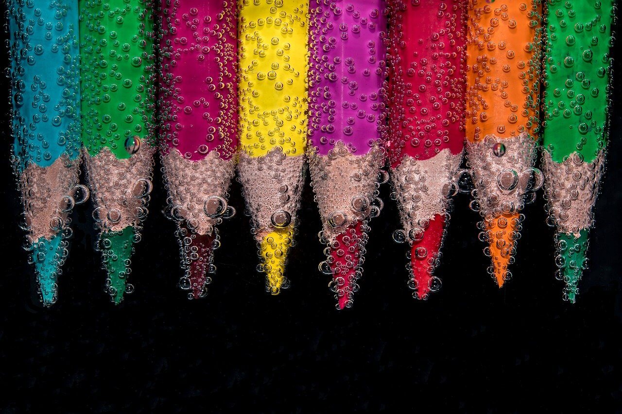 Imagen de varios lápices de colores sumergidos en agua